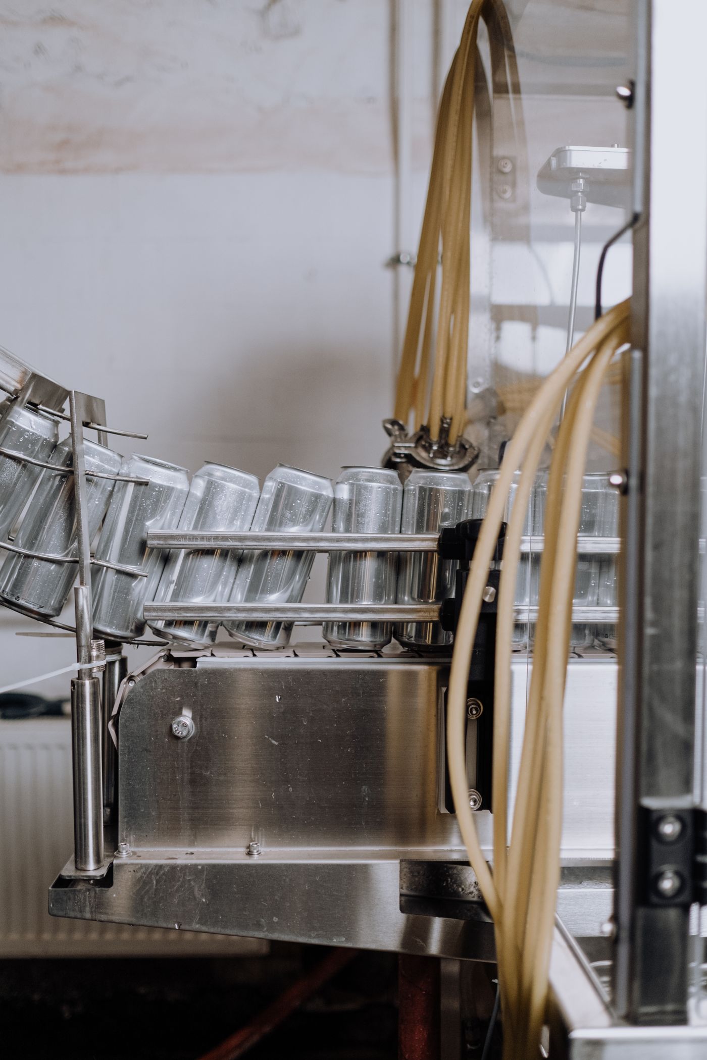 Rinçage des canettes vides avant remplissage sur une ligne de brasserie.